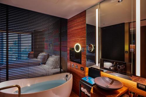a bathroom with a large tub and a sink at H2O HOTEL in Kaohsiung