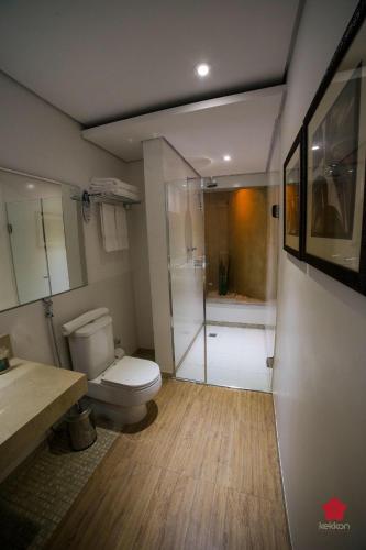 a bathroom with a shower and a toilet and a sink at Abayomi Hotel in Ilhabela