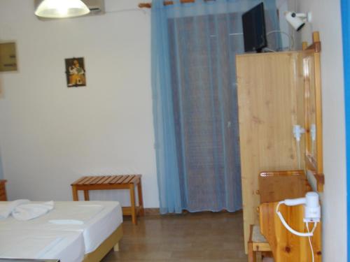 a bedroom with a bed and a television and a table at Ethra in Patitiri