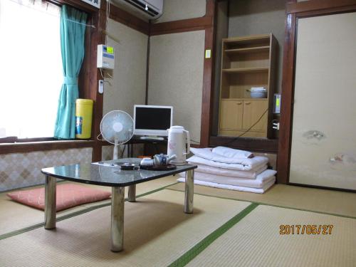 a room with a table and a computer in it at YOKOSO Ryokan in Beppu