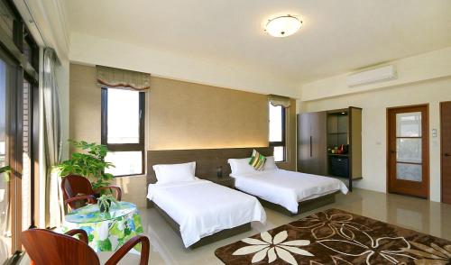 1 dormitorio con 2 camas, mesa y sillas en Residents with easy places en Taitung