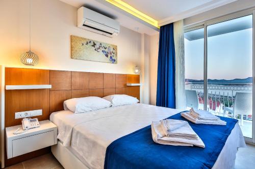 a hotel room with a large bed and a window at Kaş Artemis Hotel in Kaş