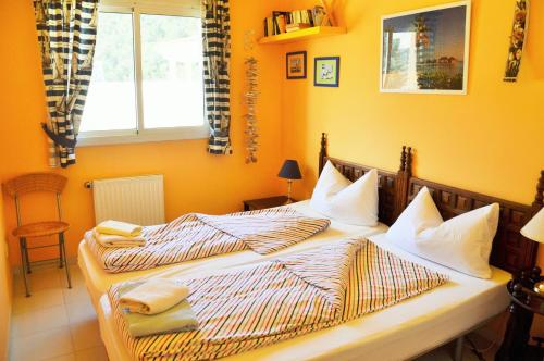 two twin beds in a bedroom with yellow walls at Can Tapsy in Tossa de Mar