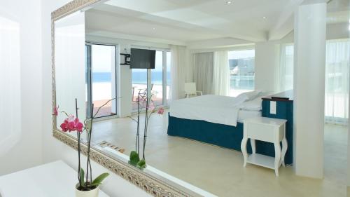 um quarto com um espelho, uma cama e uma secretária em Ibiscus Hotel in Ilha de Rhodes