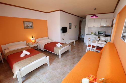 a hotel room with two beds and a kitchen at Aris Studios in Hersonissos
