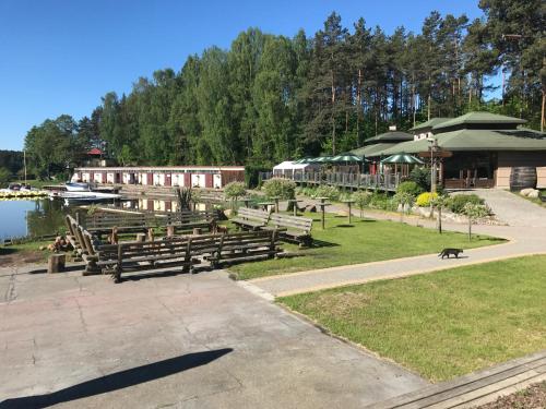 a group of benches in a park next to a lake at Domki Kaszuby - jezioro las i zoo w Szarlocie in Kościerzyna