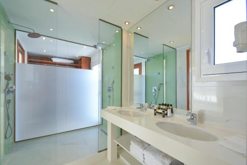 een badkamer met 2 wastafels en een grote spiegel bij Ibiscus Hotel in Rhodos-stad