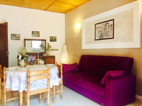 トロペアにあるLaura Holiday Homeの紫色のソファとテーブル付きのリビングルーム