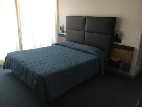 una camera con letto e copriletto blu di Albergo Valle d'Oro ad Albino