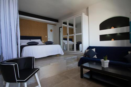 a bedroom with a bed and a chair and a table at Galaxy Suites & Villas in Imerovigli