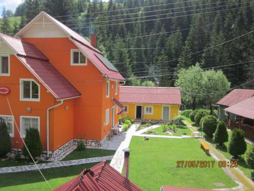 an orange and yellow house with a yard at Pensiunea Marydor in Gîrda de Sus