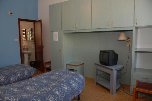Zimmer mit einem Bett und einem TV auf dem Tisch in der Unterkunft Hotel "Locanda Gaia" in Muggia