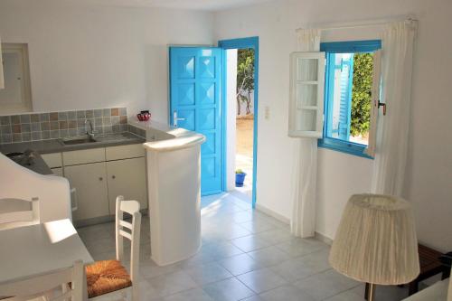 cocina con puerta azul y fregadero en Meltemi Studios and Apartments, en Logaras