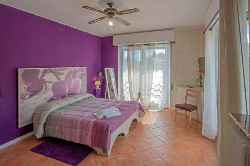 ストレーザにあるAffittacamere Caffè Nazionaleの紫色のベッドルーム(ベッド1台、天井ファン付)