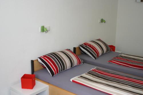 ein Bett mit zwei Kissen und einer roten Box in der Unterkunft Ferienwohnung mit Herz für Tiere in Kaufbeuren