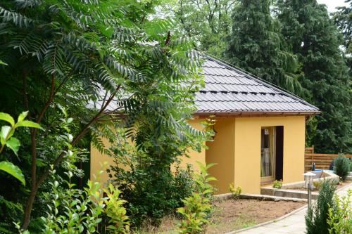 a small yellow house with a black roof at Areal Hradišek in Klobouky u Brna