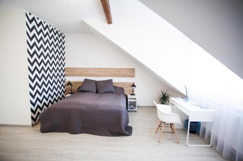 a bedroom with a bed and a desk in a attic at Haas Apartments in Brno