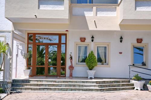 a house with a front door with potted plants at Kalloni Bay in Skala Kallonis