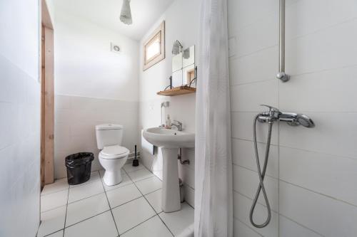 ein weißes Bad mit einem WC und einem Waschbecken in der Unterkunft Oasis Club Cottages in Udabno