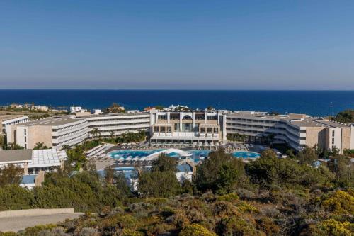 a view of a hotel with the ocean in the background at Princess Andriana Resort & Spa - Ultra All-Inclusive in Kiotari