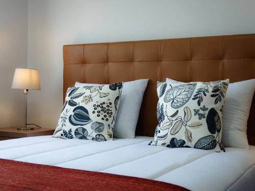 a bed with blue and white pillows on it at RS Porto Apartments in Porto