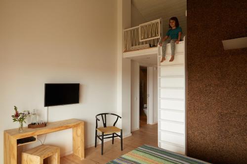 a child sitting on top of a bunk bed in a room at Cavalo de Madeira in Arelho