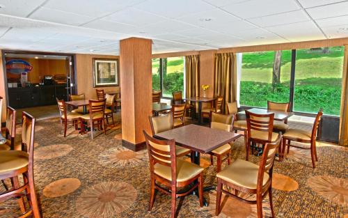 a dining room with tables and chairs and windows at Baymont by Wyndham Branson - On the Strip in Branson