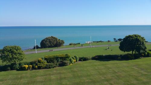 a green field with trees and a road in the distance at Westward Ho Hotel in Folkestone