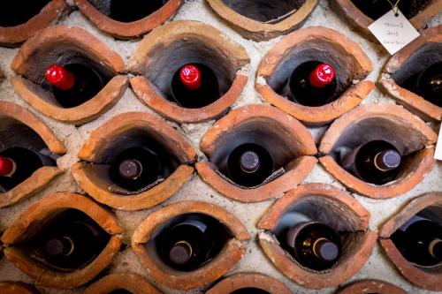 a wall of wine bottles with red cherries in them at Tenuta Del Gallo in Amelia