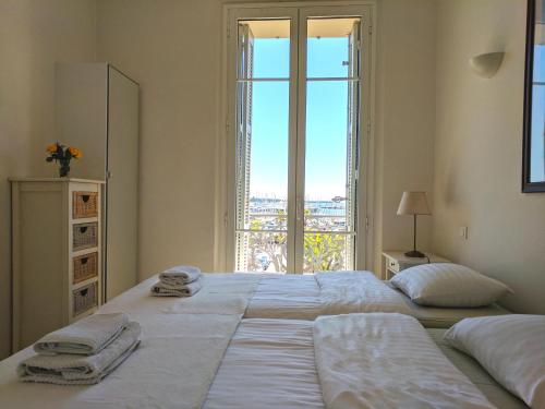 een slaapkamer met een groot bed met handdoeken erop bij Citilet Louis Blanc 1,2,3 - Three gorgeous, open-plan apartments in Cannes