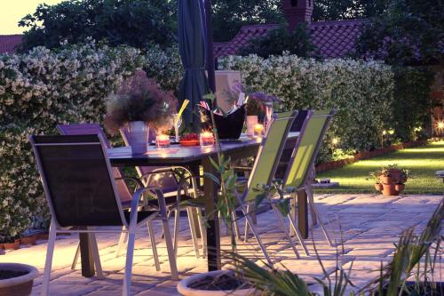 a table and chairs in a garden with lights at Apartmaji Sobe Zvezda in Pobegi