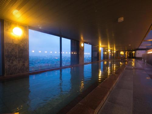 a swimming pool in a building with a view at Bourou Noguchi Hakodate in Hakodate