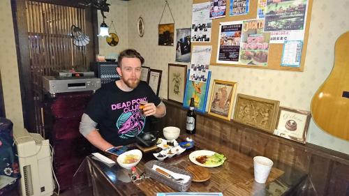 a man sitting at a counter in a restaurant at Live Cafe Hisui no Umi in Itoigawa