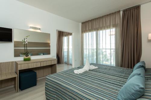 A bed or beds in a room at Kapetanios Bay Hotel Protaras