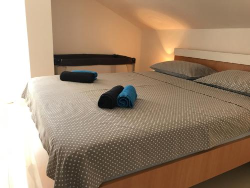 a bed with two blue pillows on top of it at Apartment Ivana in Punat