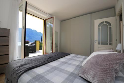 a bedroom with a large bed and a large window at Casa Ketty in Bellagio