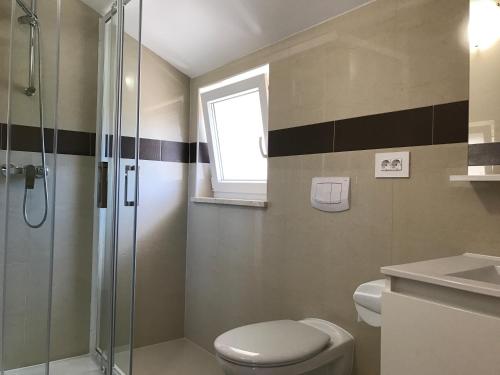 ein Badezimmer mit Dusche, Toilette und Waschbecken in der Unterkunft Apartment Ivana in Punat