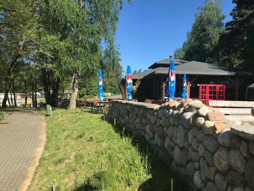 a stone wall with flags in front of a building at Domki Kaszuby - jezioro las i zoo w Szarlocie in Kościerzyna