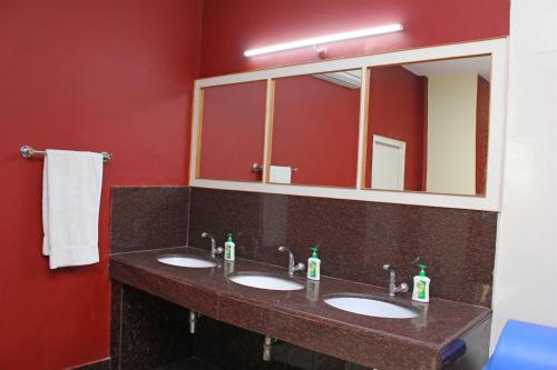 La salle de bains est pourvue de 2 lavabos et d'un grand miroir. dans l'établissement Hotel Shikhar & Restaurant, à Almora
