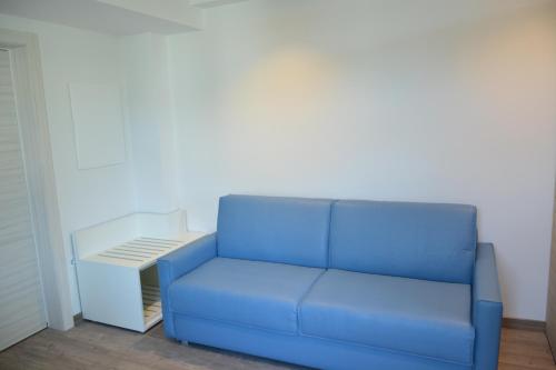 a blue couch in a room with a white wall at Grand Hotel Liberty in Riva del Garda