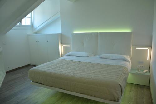a bedroom with a large white bed in a loft at Grand Hotel Liberty in Riva del Garda