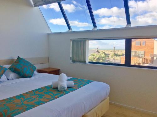 a bedroom with two beds and a large window at BeachLife Apartments in Christchurch