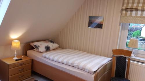 a small bed in a small room with a window at Gästezimmer Grimmelmann in Eystrup