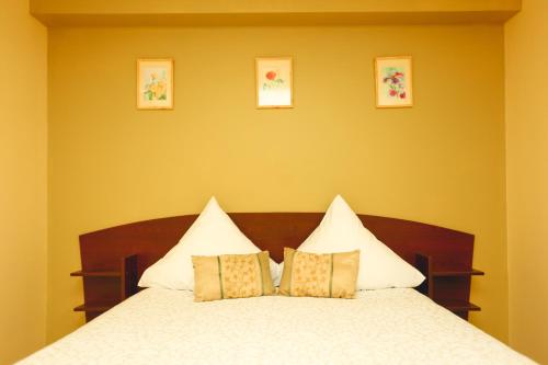 a bedroom with a white bed with three pillows at Arciau Juros in Palanga