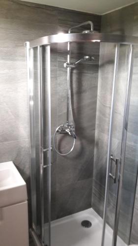 a shower with a glass door in a bathroom at Penzión Chata Valaška in Dolný Smokovec