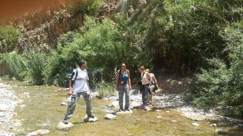 a group of people standing in a river at Oasis de Tiout in Tiout