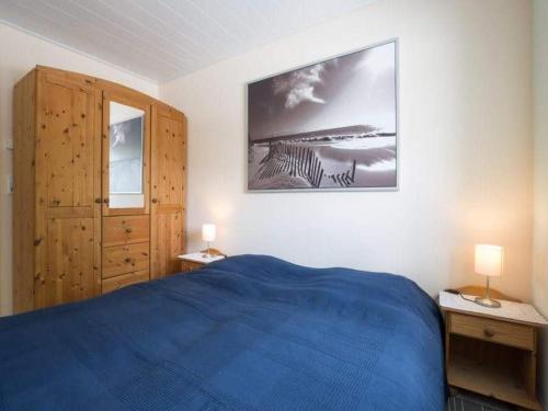 a bedroom with a blue bed and a picture on the wall at Hof am Redder in Lindewitt