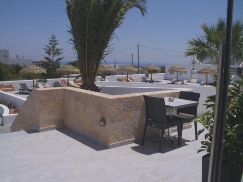 a patio with a table and chairs on a roof at Nikos Hotel in Karterados