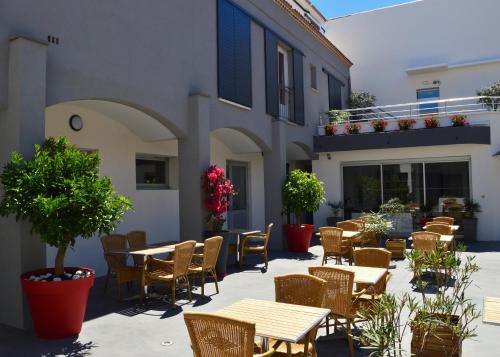 ル・グロー・デュ・ロワにあるHotel Les Acaciasの屋外パティオ(テーブル、椅子、植物付)