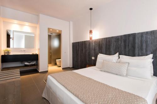 a bedroom with a large bed and a bathroom at Villa Kelly Rooms & Suites in Naousa